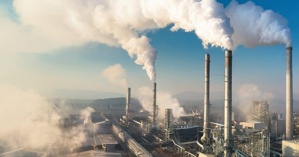 factories emitting smoke into atmosphere